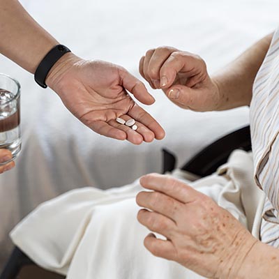 Ofreciendo medicación de pastillas a paciente.